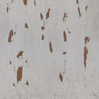 Close-up of distressed white painted finish with scattered brown flecks