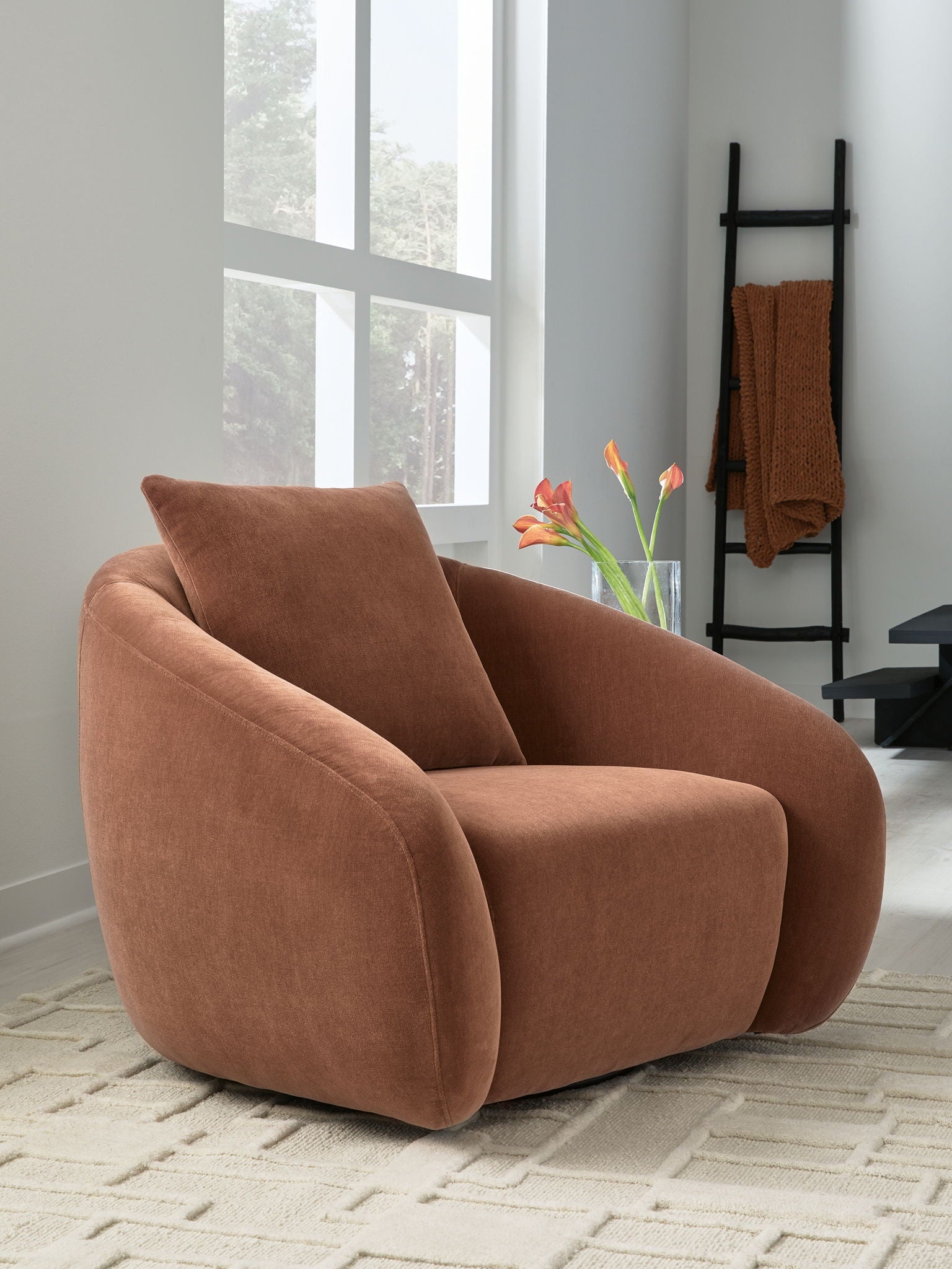 Brown swivel accent chair with rounded arms, plush seat, and curved backrest