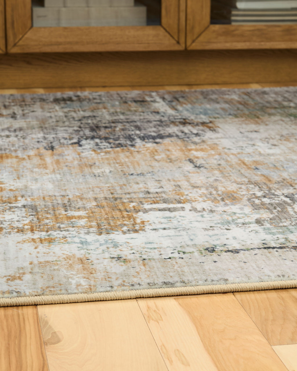 Abstract area rug close-up with low pile and cream, blue-gray, rust flecks
