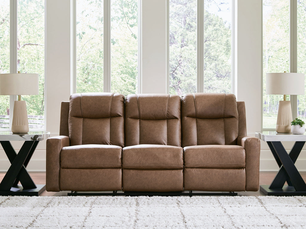 Light brown reclining sofa with three padded headrests and tufted back and seat cushions
