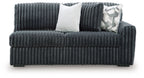 Gunmetal ribbed sofa with cushioned seat, backrest, and two accent pillows
