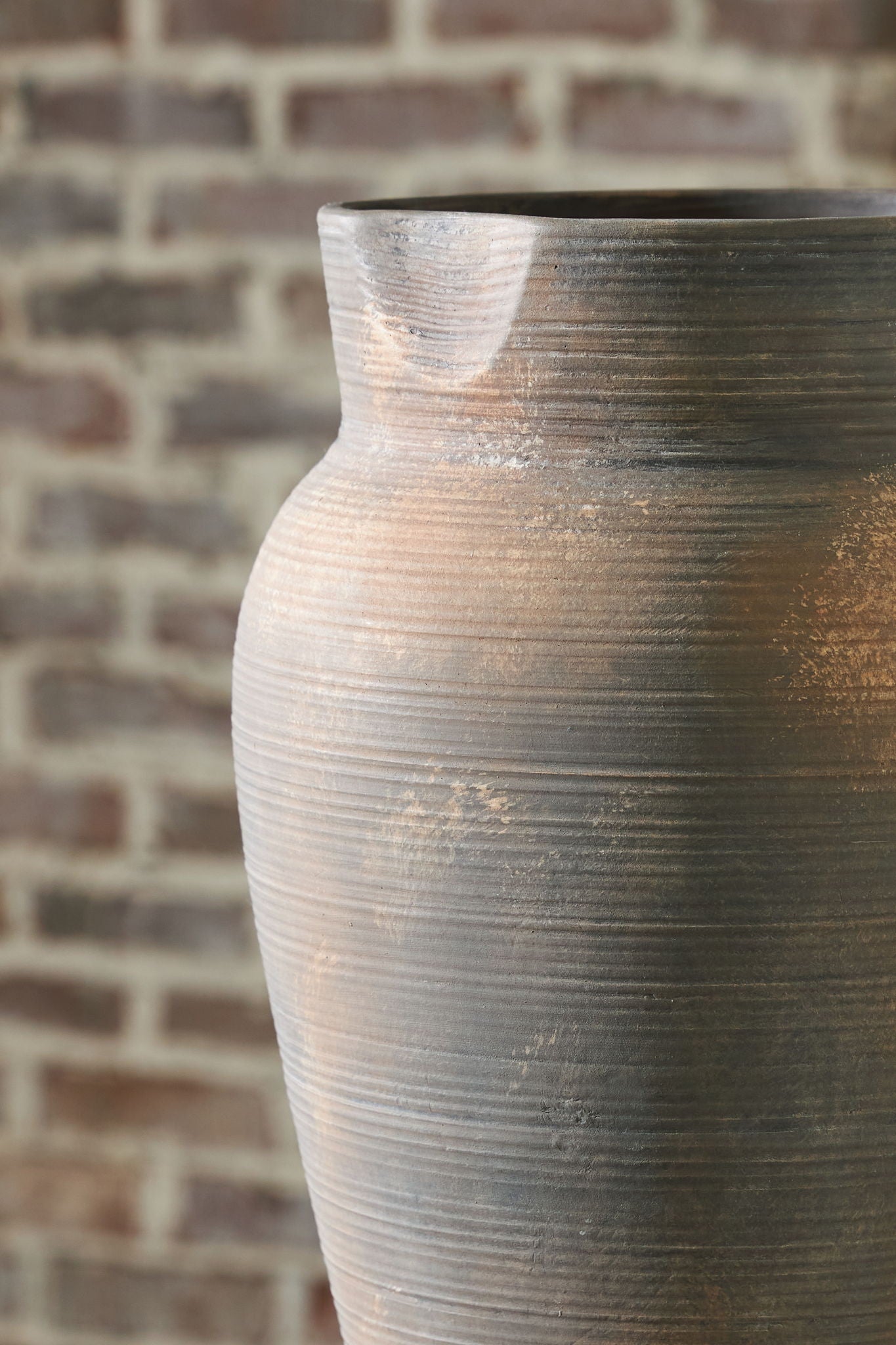 Antique gray vase angled view with curved shoulder, wide opening, and horizontal texture lines
