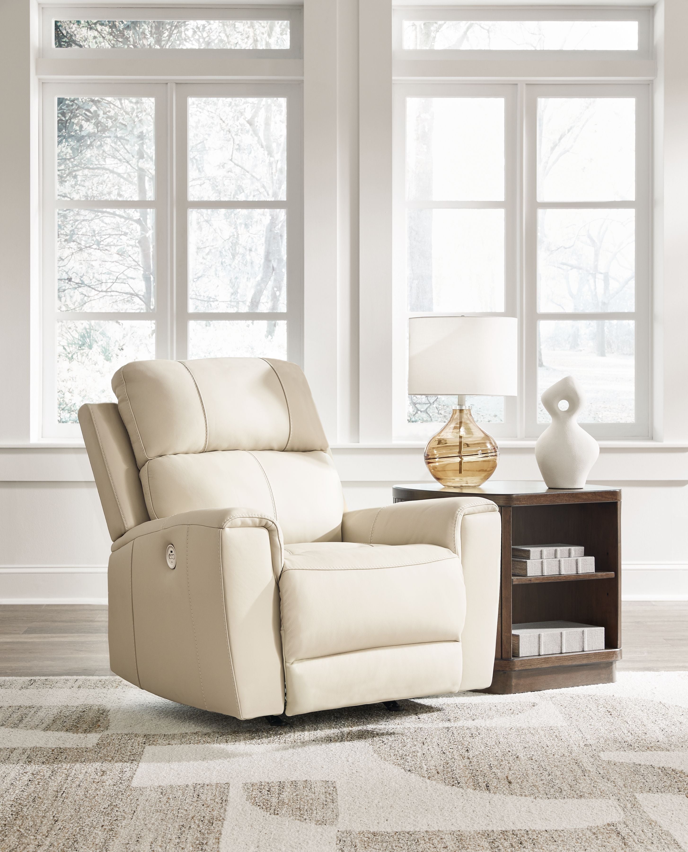 Light beige power rocker recliner with padded headrest and seat cushions