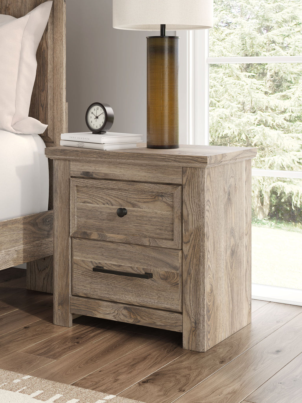 Brown two-drawer night stand with black knob and bar handle, placed beside a bed.