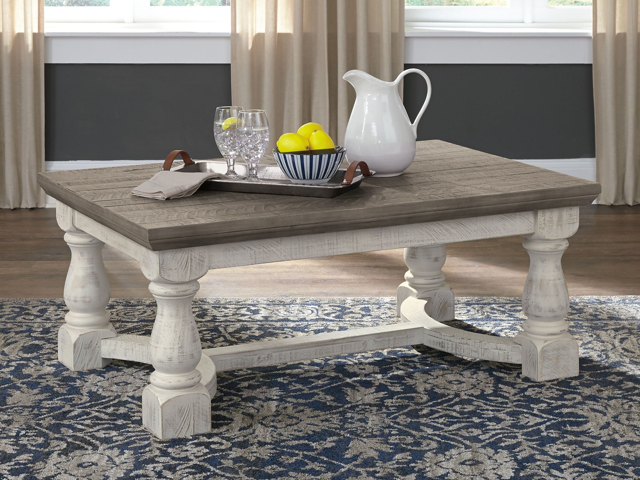Rectangular cocktail table with gray top and white pedestal legs
