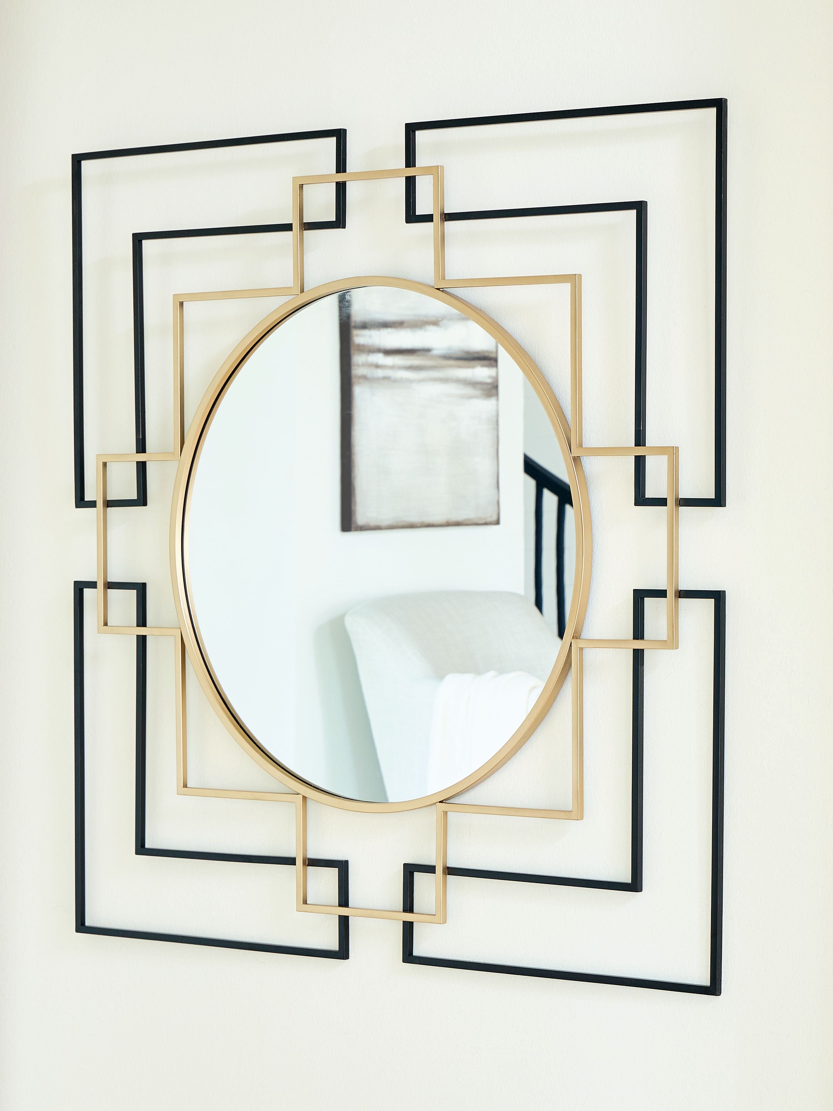 Round accent mirror with gold edge and black geometric frame, showing reflected room.