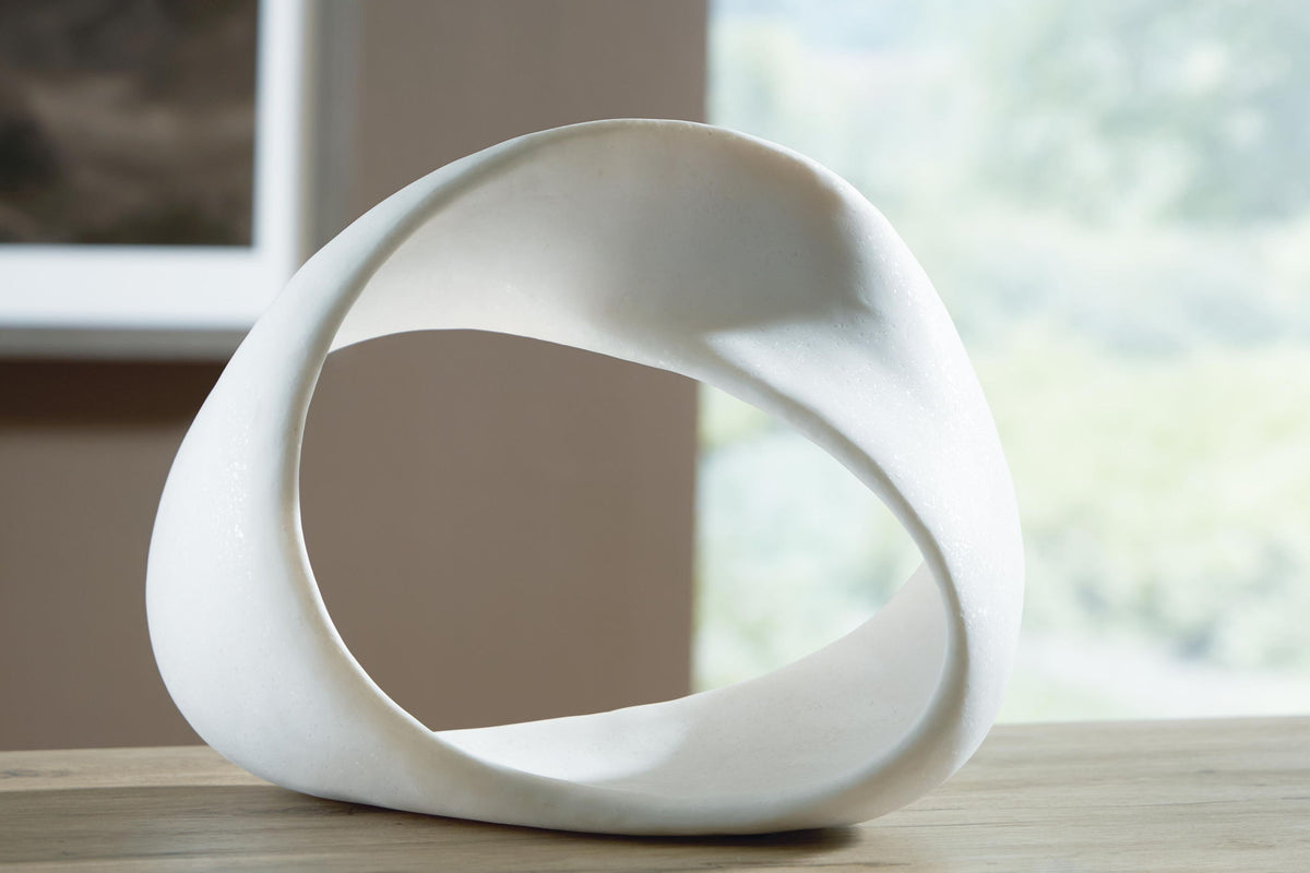 White abstract sculpture with large circular opening, smooth matte finish.
