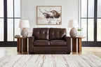 Dark brown leather-look loveseat with tufted backrest and split seat cushions