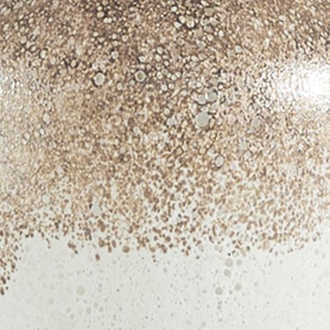 Speckled lamp glass surface with gold flecks over white glass.