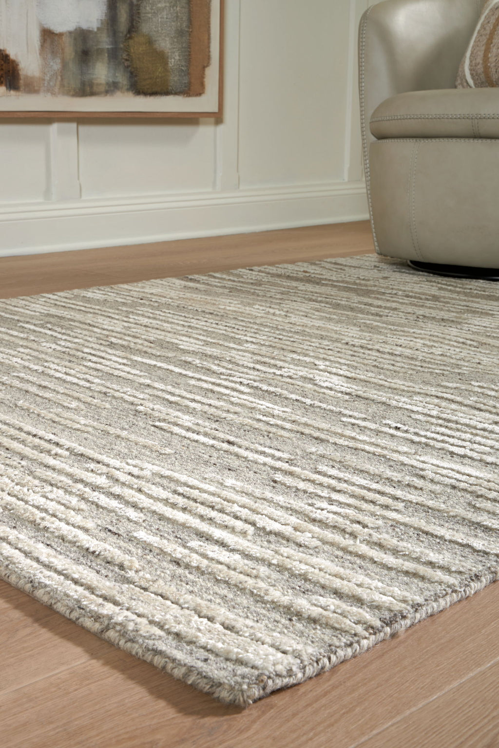 Gray area rug corner with textured stripe weave and short, flat pile