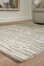 Gray area rug corner with textured stripe weave and short, flat pile