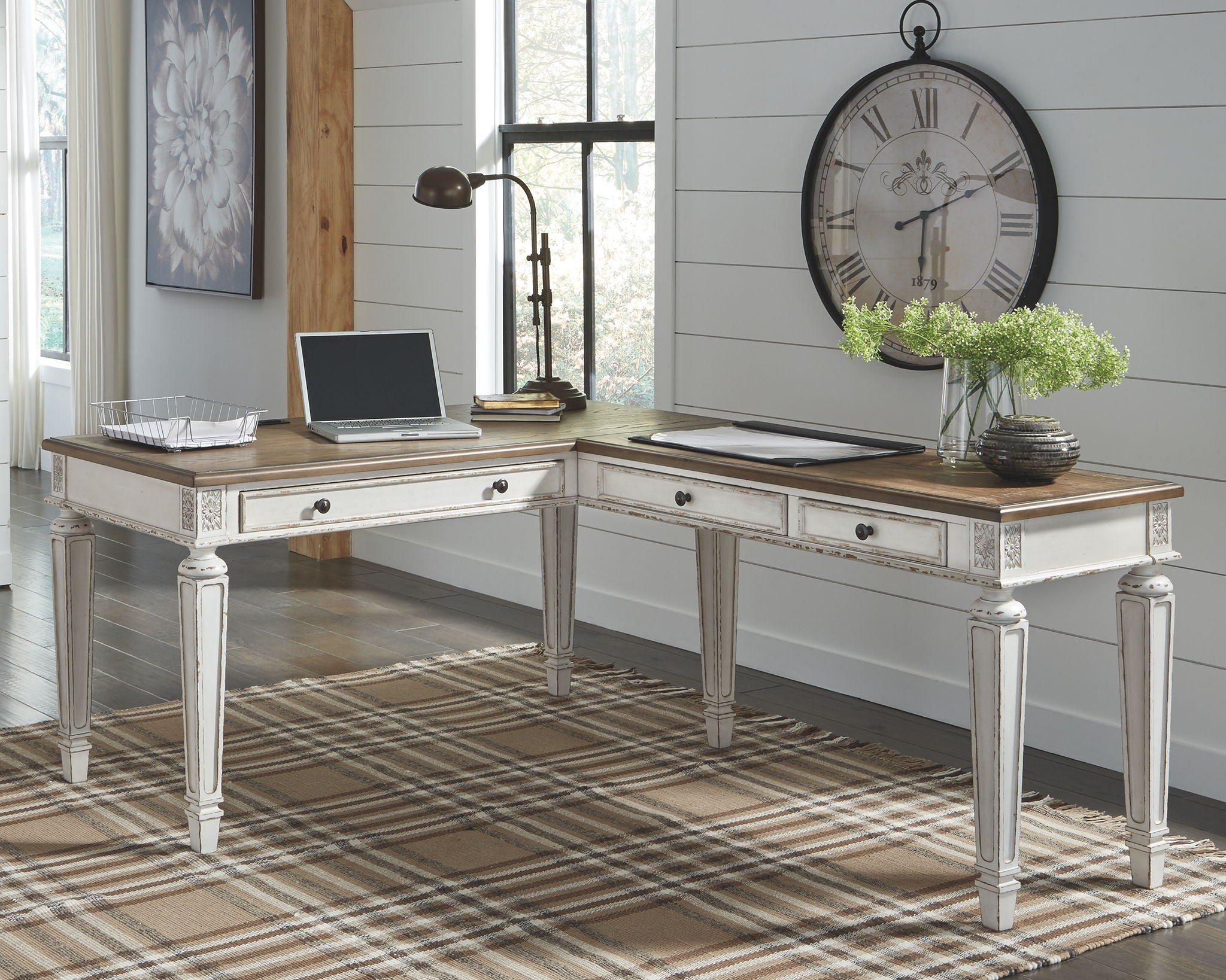 L-shaped home office desk with light wood surfaces, white cabinets, and drawer pulls