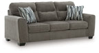 Dark gray fabric loveseat with tufted back, padded arms, and two striped throw pillows