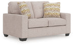 Gray upholstered loveseat with two square decorative pillows, gold and beige geometric pattern