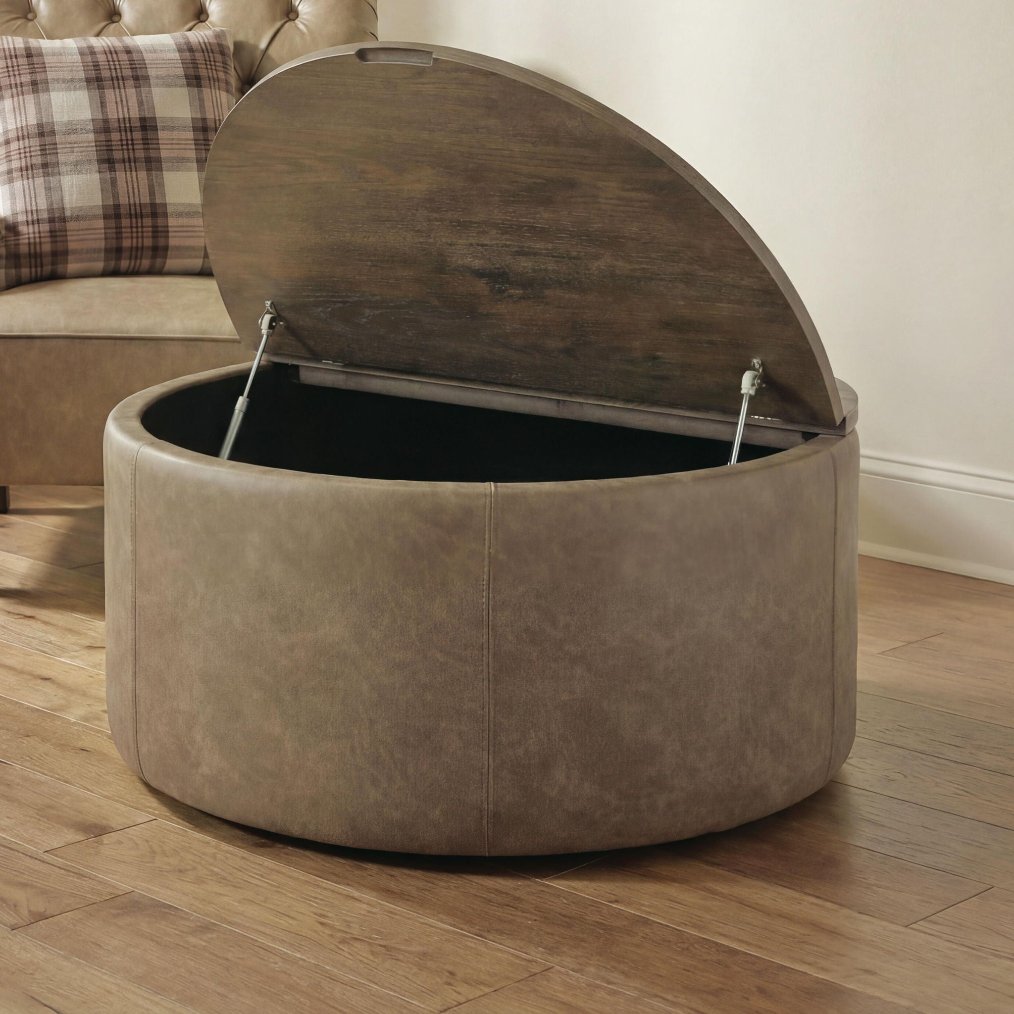 Round warm brown storage ottoman with open hinged lid and visible inner storage