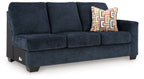Ink blue fabric sofa with three seat cushions and patterned throw pillow