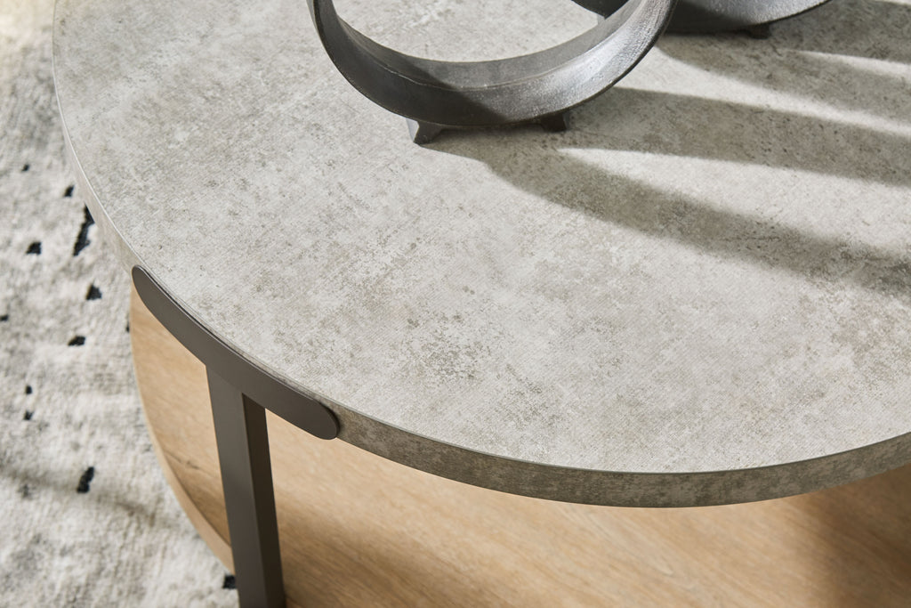 Close-up of round table edge with gray top and light brown apron on legs