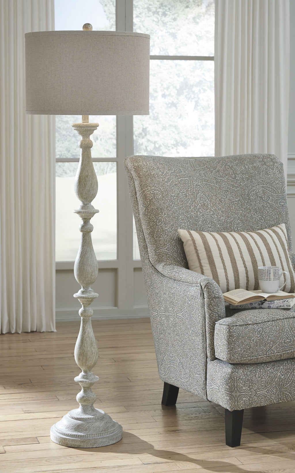 Whitewash poly floor lamp with beige fabric drum shade and round carved base