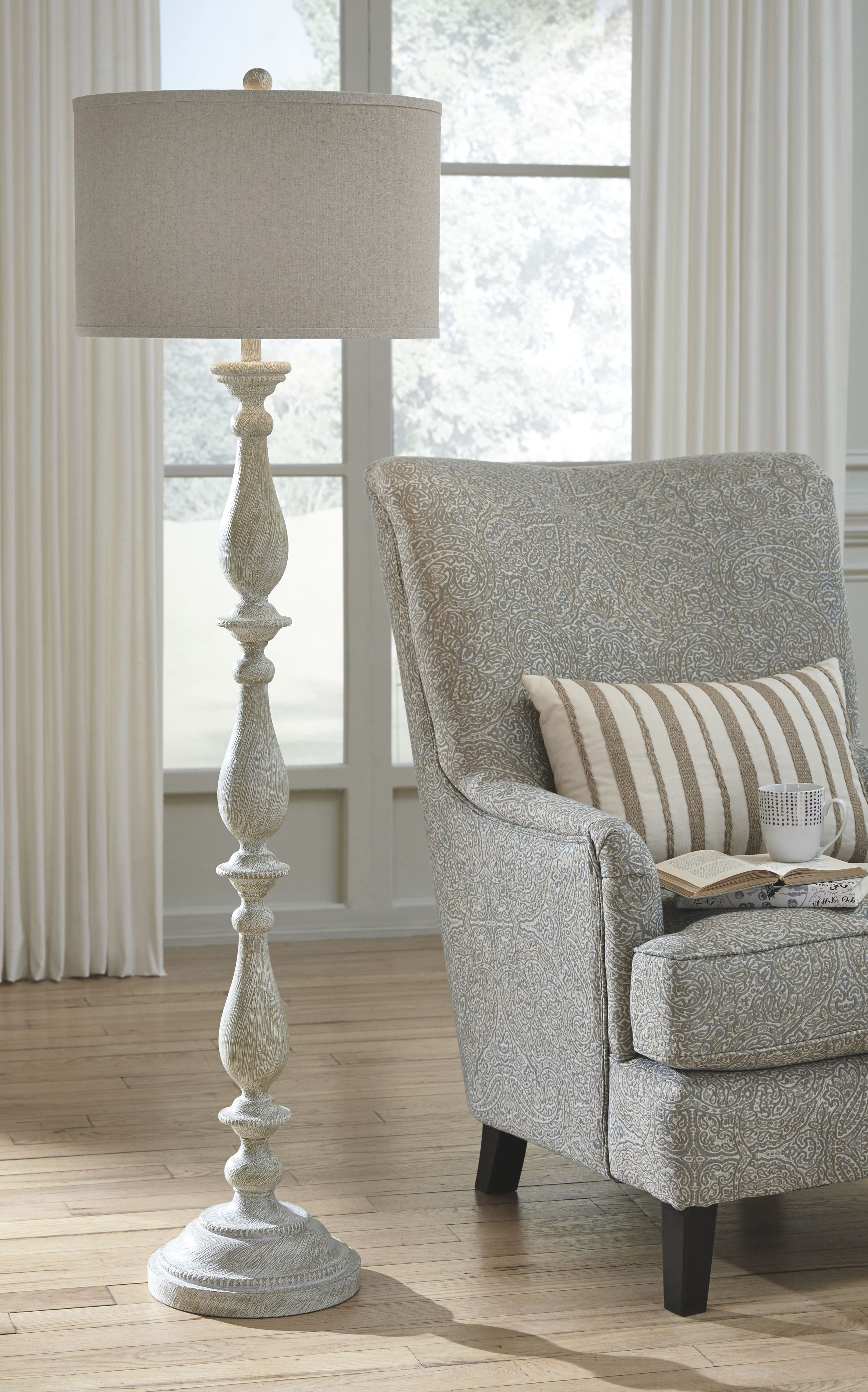Whitewash poly floor lamp with beige fabric drum shade and round carved base