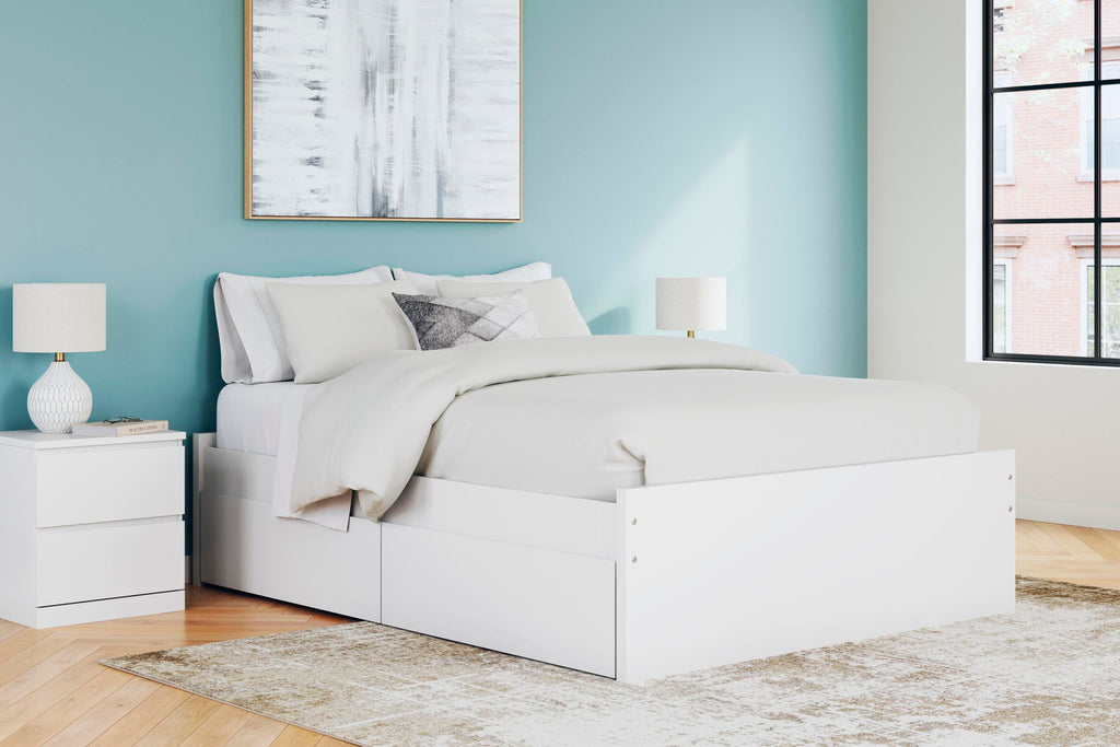 White platform bed with two side drawers, slat base, and bed pillows