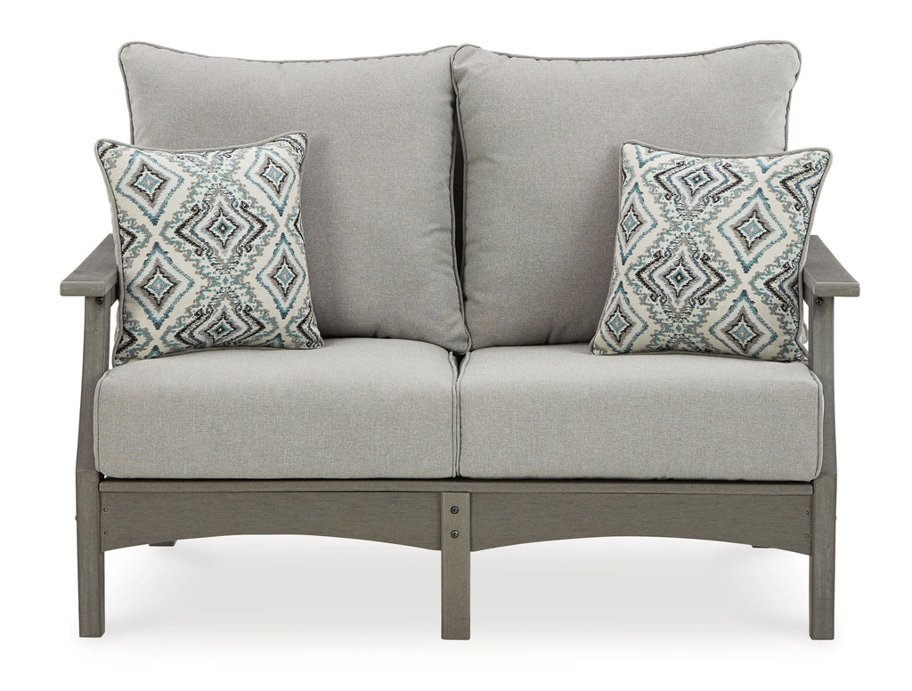 Gray outdoor sofa with two back pillows and two diamond-pattern throw pillows