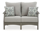 Gray outdoor sofa with two back pillows and two diamond-pattern throw pillows
