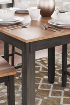 Rectangular dining table top in dark wood with chair legs and apron, close-up