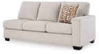 Light beige fabric sofa with squared arms, three seat cushions, and patterned lumbar pillow