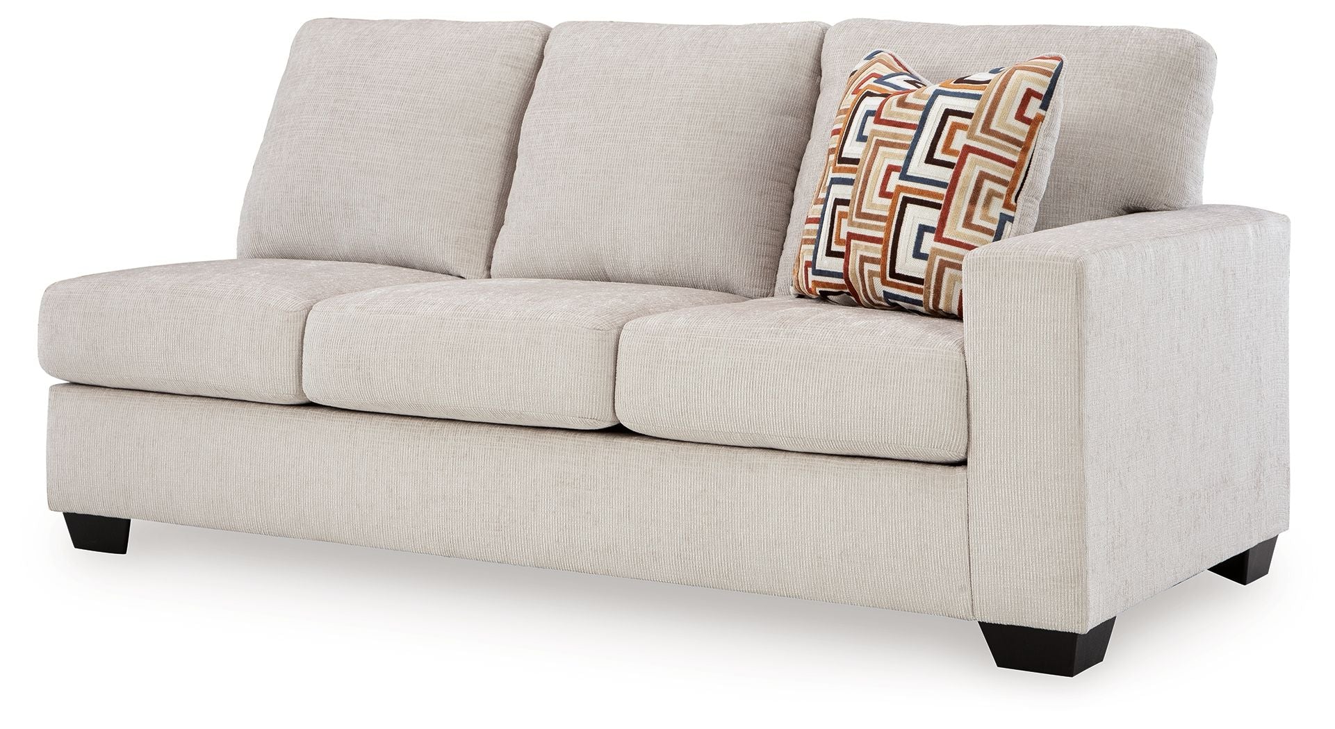 Light beige fabric sofa with squared arms, three seat cushions, and patterned lumbar pillow