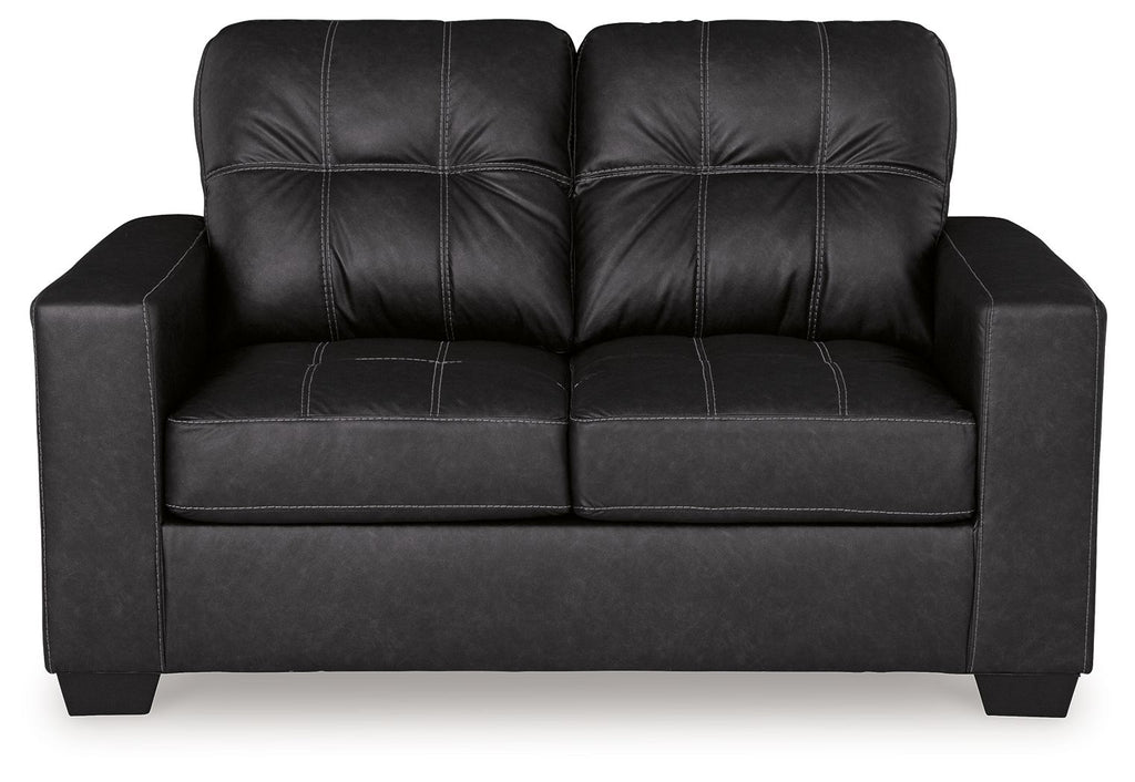 Black loveseat front view with tufted back and padded arms over a boxy seat