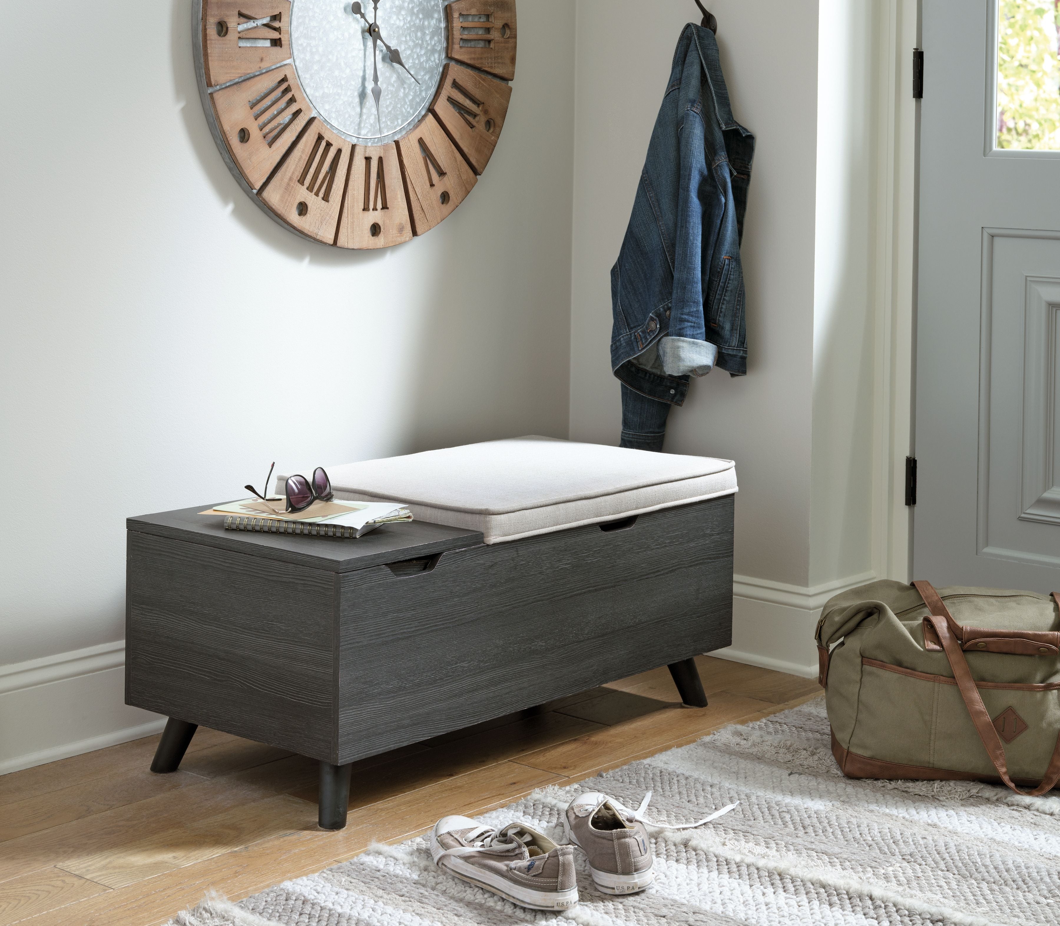 Dark gray storage bench with beige cushion and lift-top panel
