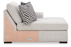 Stone corner chaise with wood side panel, tufted back, striped accent pillow.