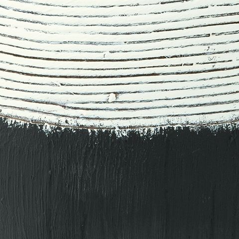 Close-up of vase midsection: white striped top over dark black textured base