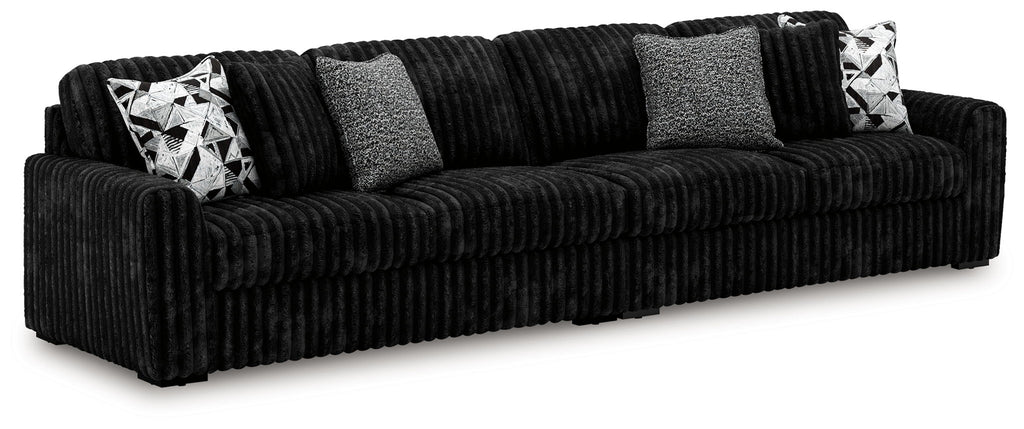 Charcoal sectional sofa with deep seat and multiple geometric-pattern throw pillows.