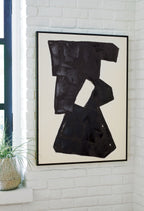 Framed abstract wall art with dark black geometric forms and a hollow cutout