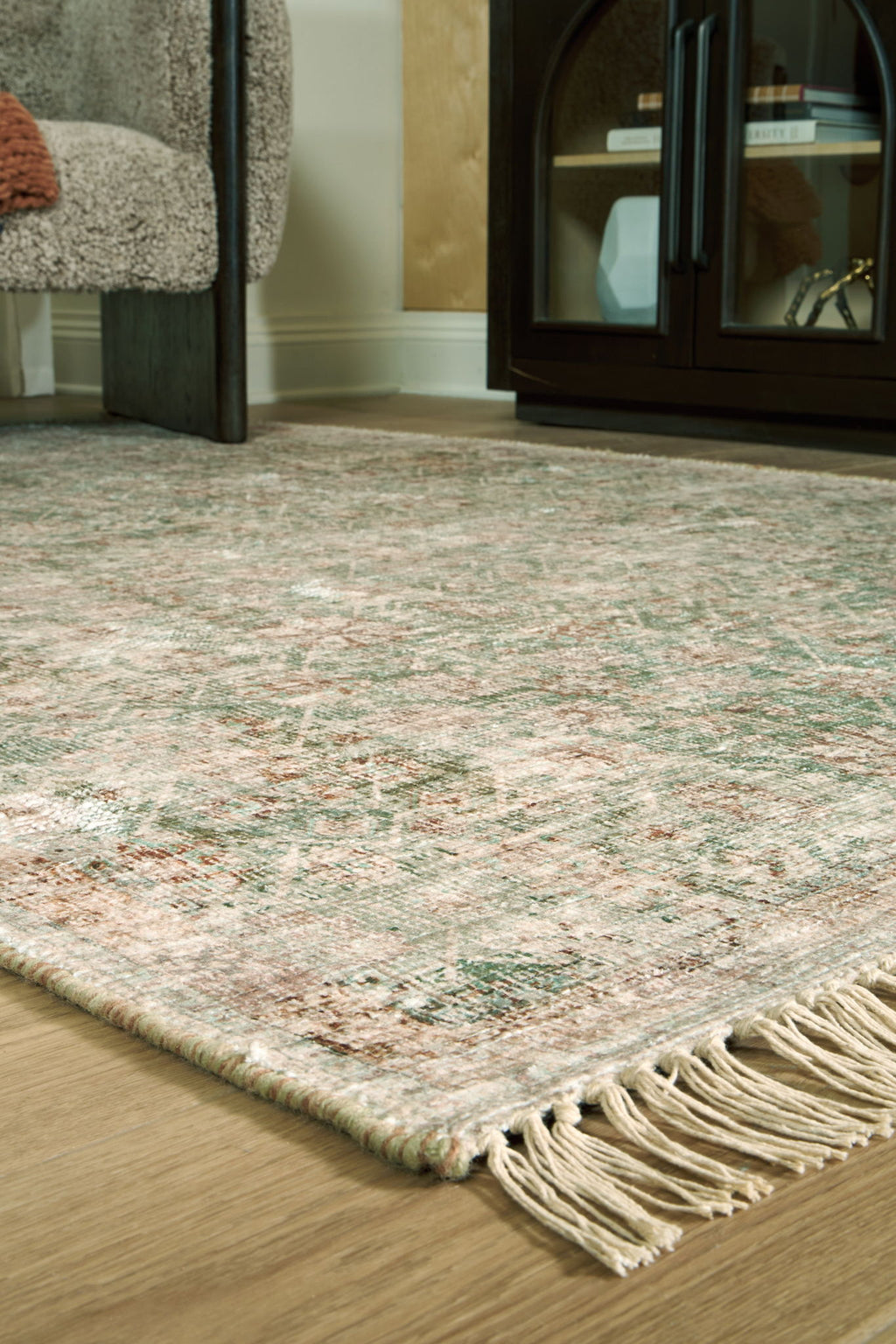 Rossbury rug corner detail, speckled multicolor texture with cream fringe tassels