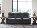 Black reclining sofa with tufted back cushions and wide segmented seat with armrests