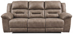 Taupe-gray power reclining sofa with padded arms and segmented back cushions.