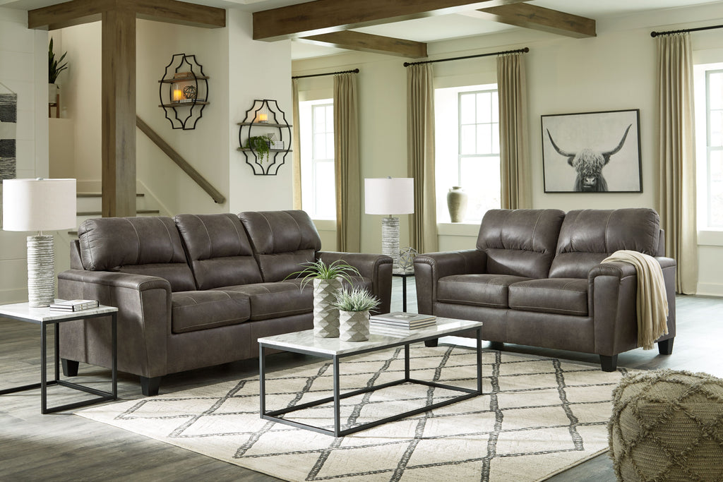 Dark gray sofa and loveseat with padded arms and tufted back cushions