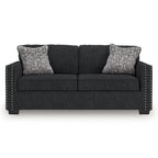 Coal fabric sofa with nailhead trim, arm details, and two heather gray throw pillows