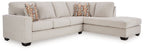 Light beige sectional sofa with corner chaise and patterned pillows along the backrest