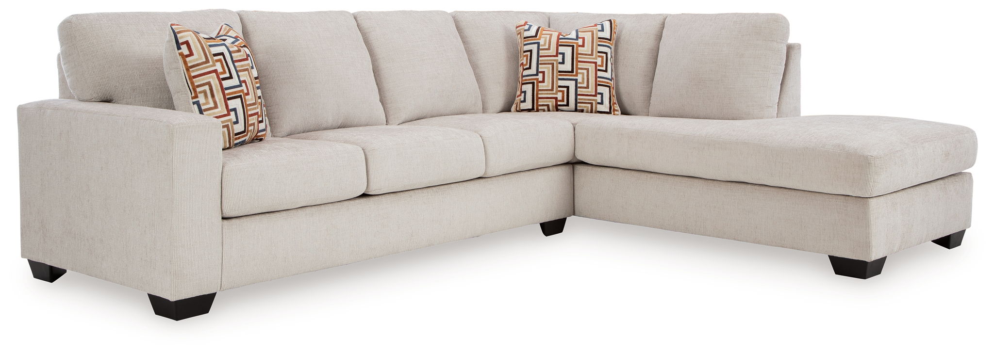 Light beige sectional sofa with corner chaise and patterned pillows along the backrest