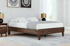Platform bed with light brown wood frame and white bedding, low platform style