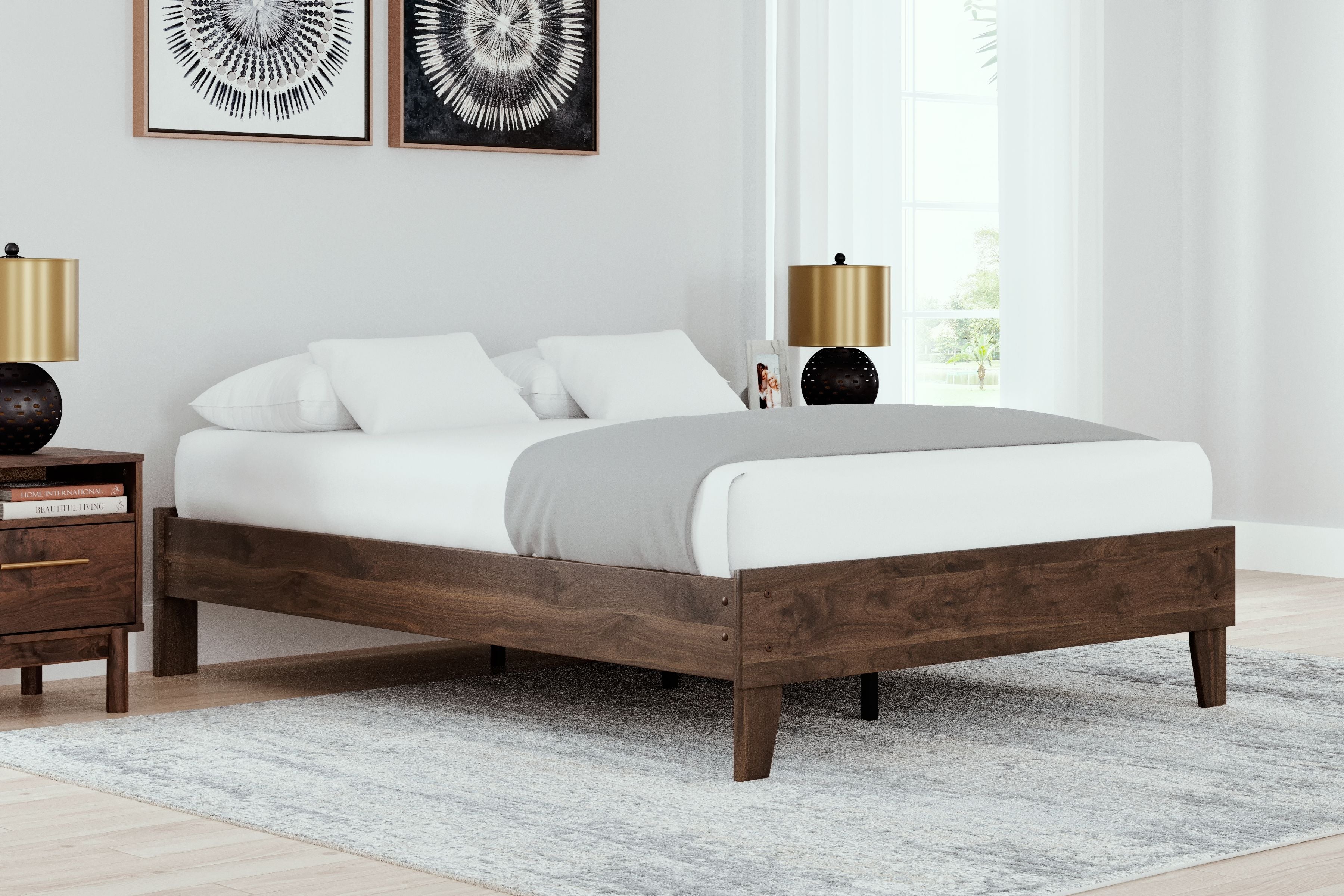 Platform bed with light brown wood frame and white bedding, low platform style
