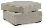 Light beige fabric storage ottoman with hinged lid and black feet