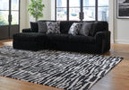 Black corduroy sectional sofa with chaise corner and gray patterned pillows