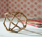 Laddington sculpture: light brown open frame with crisscross bars, angled view.