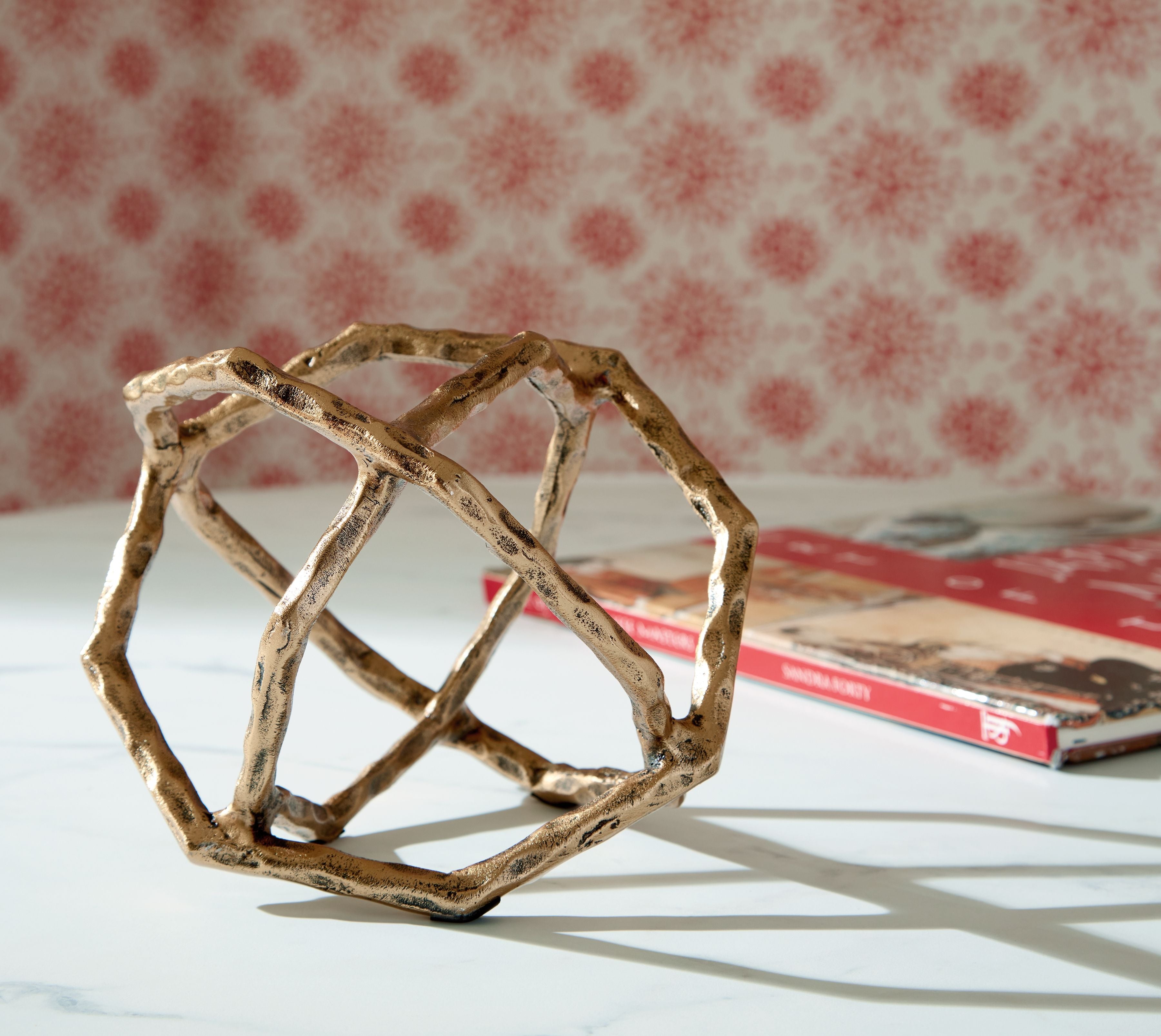 Laddington sculpture: light brown open frame with crisscross bars, angled view.