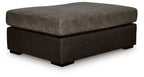 Oversized accent ottoman with square padded top, dark brown fabric, low wooden feet.