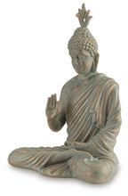 Seated Buddha sculpture with green patina, side view with raised palm and folded legs